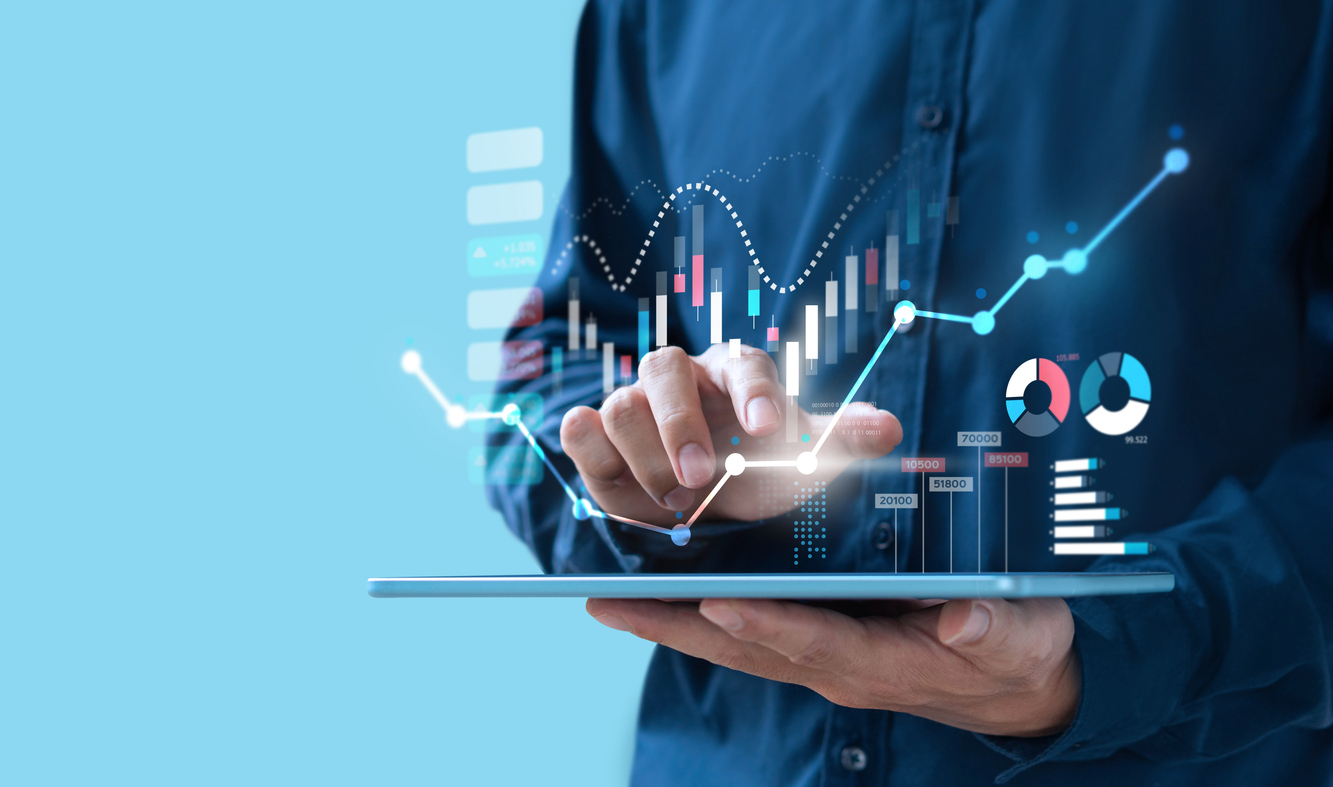 Man interacting with a digital tablet displaying financial charts and data graphs.